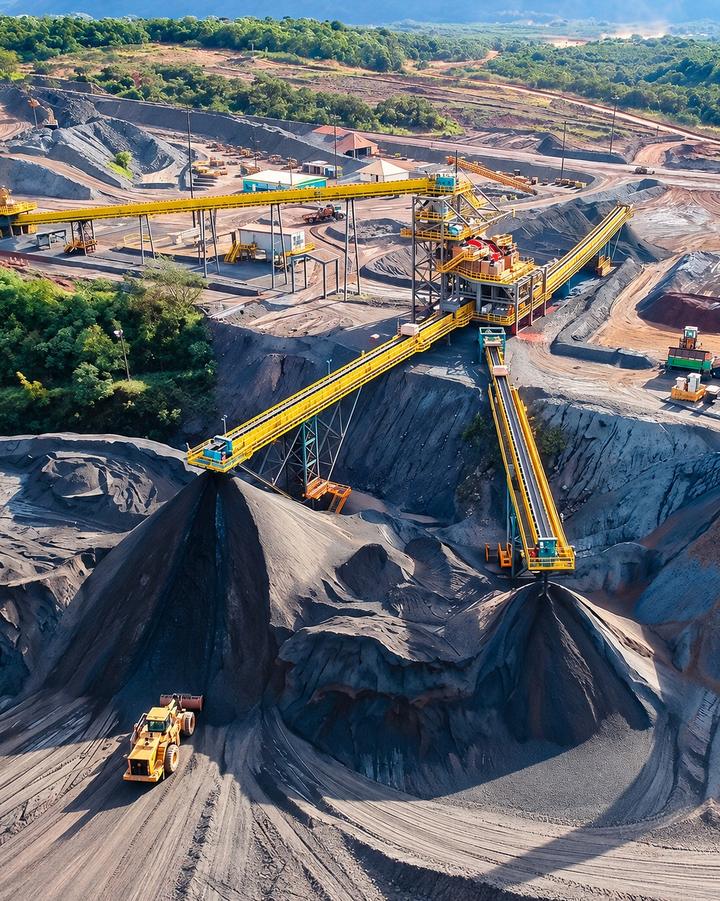 Vista aérea de planta de mineração com transportadores de correia formando pilhas de minério